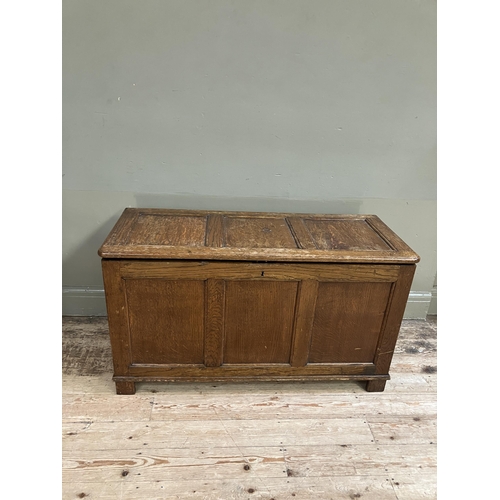 261 - An oak blanket box having a triple indented panel top and conforming front on style feet, 108cm x 46... 