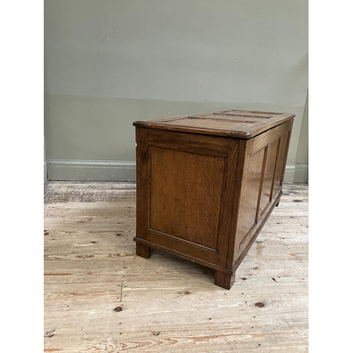 261 - An oak blanket box having a triple indented panel top and conforming front on style feet, 108cm x 46... 