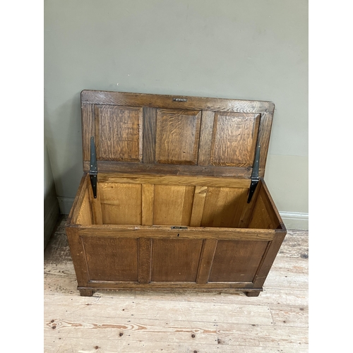 261 - An oak blanket box having a triple indented panel top and conforming front on style feet, 108cm x 46... 