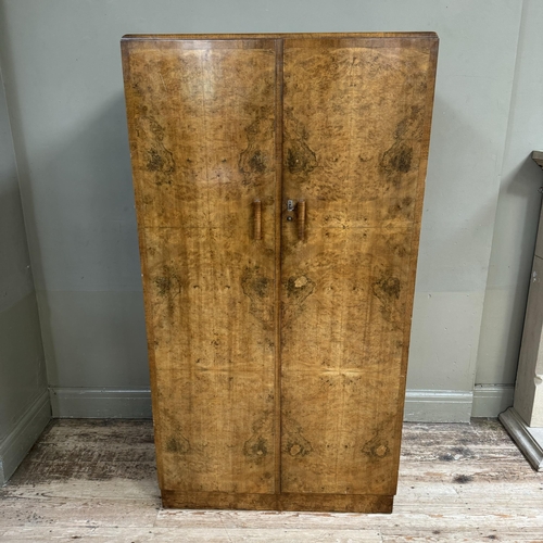 276 - A 1930s gentleman's walnut wardrobe having two doors the interior fitted with two open compartments ... 