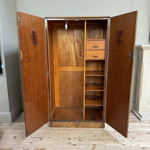 276 - A 1930s gentleman's walnut wardrobe having two doors the interior fitted with two open compartments ... 