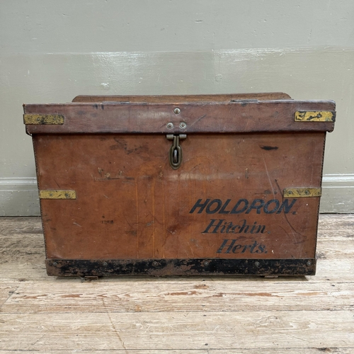 277 - An early 20th century leather trunk with brass strapwork with metal strap holders to the rear possib... 