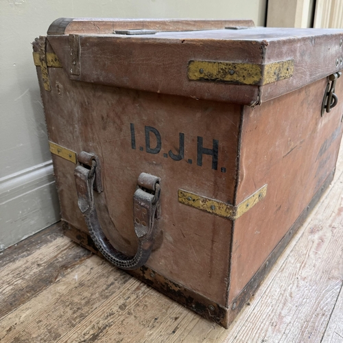 277 - An early 20th century leather trunk with brass strapwork with metal strap holders to the rear possib... 