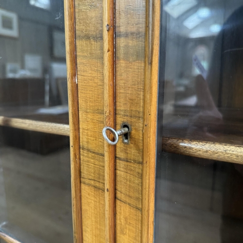 280 - A mid 20th century walnut and glazed bookcase cupboard, having a moulded cornice above two tracery g... 