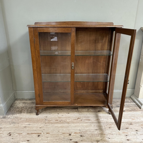 281 - A mahogany and glazed book case cupboard with a short raised back and on short cabriole legs, 114cm ... 