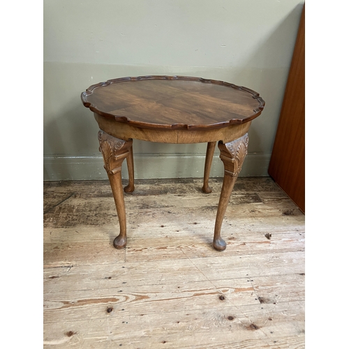 285 - A walnut quarter veneered occasional table of circular outline with pie crust rim, shell and scroll ... 