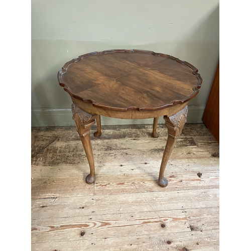 285 - A walnut quarter veneered occasional table of circular outline with pie crust rim, shell and scroll ... 