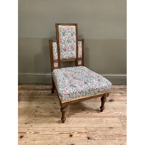 287 - A late 19th century aesthetic walnut nursing chair having a rectangular stepped back inset with pier... 