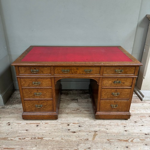 291 - A Victorian oak kneehole desk having three drawers across and three further drawers to either side o... 