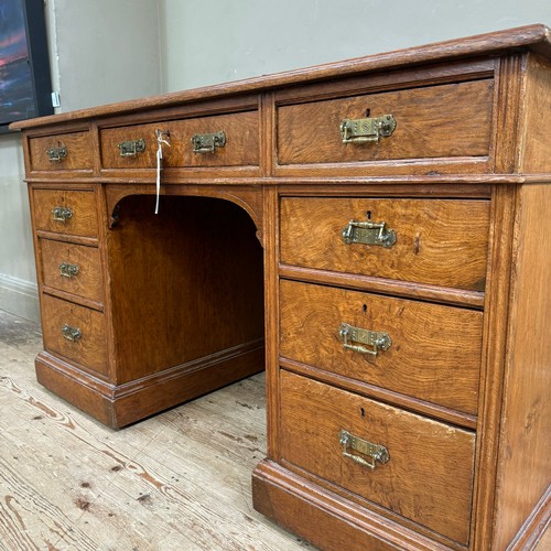 291 - A Victorian oak kneehole desk having three drawers across and three further drawers to either side o... 