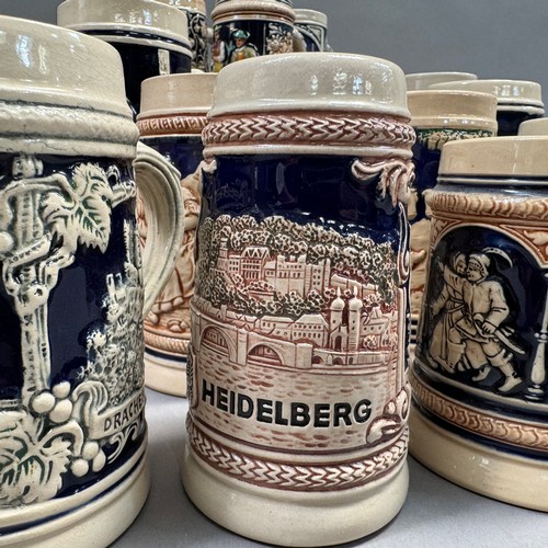 136 - A large quantity of German pottery steins glazed in blue and with relief moulded scenes