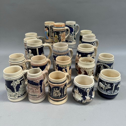 136 - A large quantity of German pottery steins glazed in blue and with relief moulded scenes