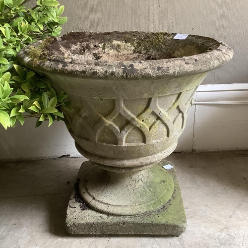 228 - A composition garden urn with relief trellis pattern on a circular foot and square plinth, 47cm x 42... 