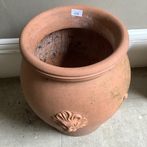 229 - A large terracotta garden pot with lion mask decoration in relief, approximately 44cm high x 40cm wi... 