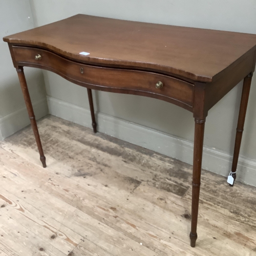 237 - A 19th century mahogany side table of serpentine outline, having a drawer to the frieze with brass k... 