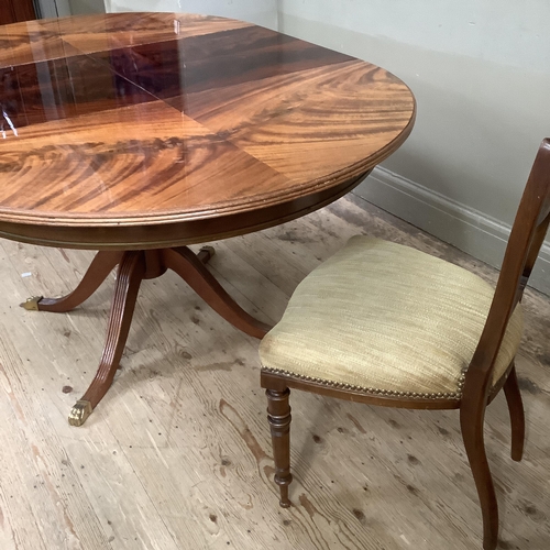 295 - A figured mahogany quarter veneered circular extending dining table on a tripod base with reeded leg... 