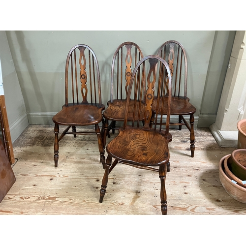 294 - A set of four Glenister elm dining chairs with pierced splat and railed back on turned legs joined b... 