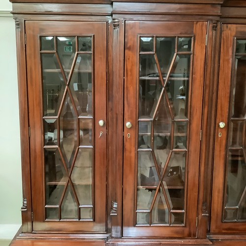 271 - A reproduction 19th century style mahogany breakfront bookcase cupboard having a moulded cornice abo... 