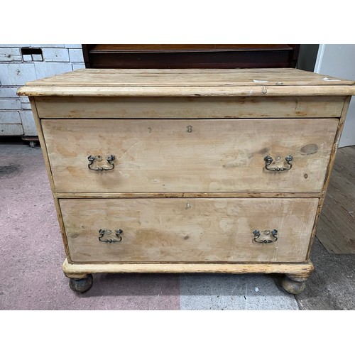 83 - A Victorian pine chest of two deep drawers with later swing handles and associated turned feet, 95cm... 