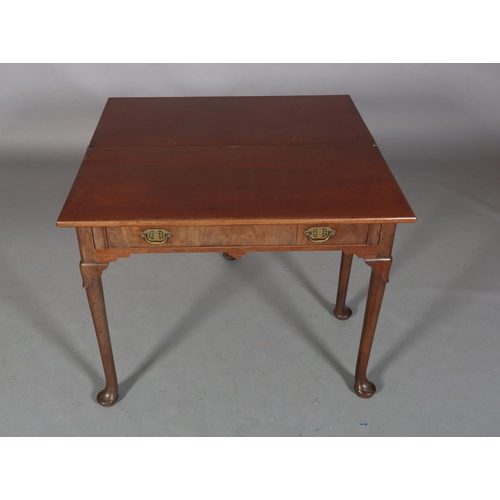 478 - A GEORGE III MAHOGANY TEA TABLE having a rectangular fold over top above a drawer to the apron, late... 