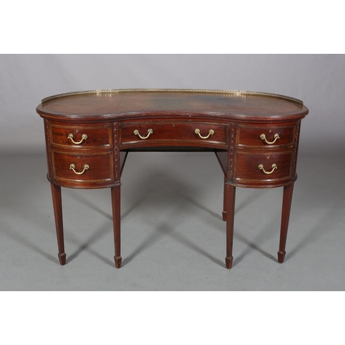 479 - A MAHOGANY KIDNEY SHAPE DESK circa 1920s, having a pierced brass gallery and leather incised writing... 