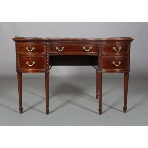 479 - A MAHOGANY KIDNEY SHAPE DESK circa 1920s, having a pierced brass gallery and leather incised writing... 