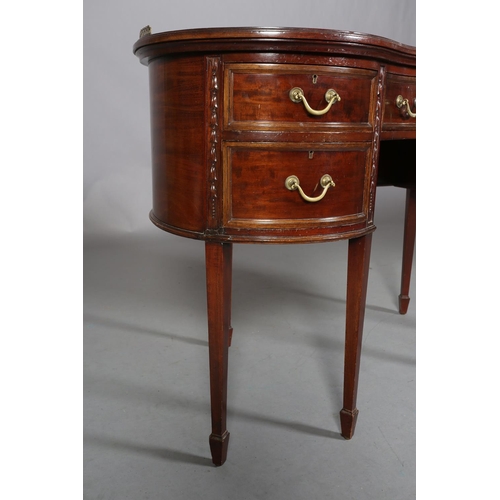 479 - A MAHOGANY KIDNEY SHAPE DESK circa 1920s, having a pierced brass gallery and leather incised writing... 