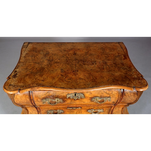 467 - A 18TH CENTURY DUTCH FIGURED WALNUT BOMBE COMMODE, the quarter veneered top of serpentine outline, a... 