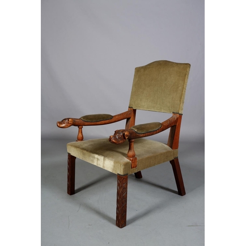 488 - A LATE 19TH CENTURY OAK OPEN ARMCHAIR having an upholstered panel back, arm pads and seat, the arms ... 