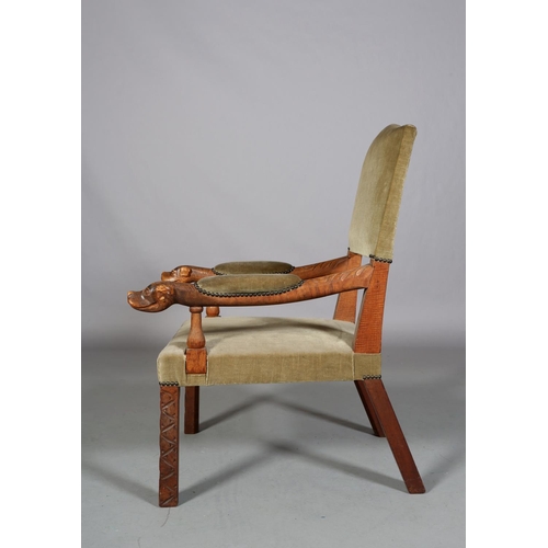 488 - A LATE 19TH CENTURY OAK OPEN ARMCHAIR having an upholstered panel back, arm pads and seat, the arms ... 