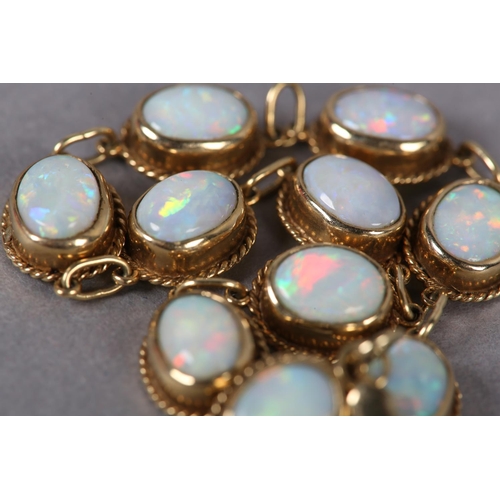 375 - AN OPAL BRACELET in 9ct gold, each link collet set with an oval cabochon stone within a twisted wire... 