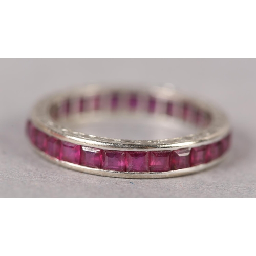 379 - A RUBY COCKTAIL RING in 18ct white gold, c1950, the calibre cut stones channel set with barley corn ... 