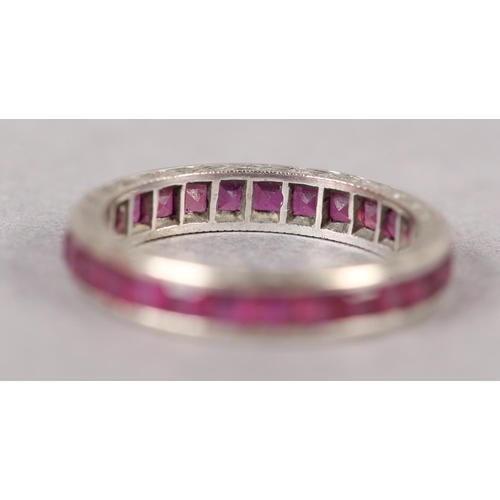 379 - A RUBY COCKTAIL RING in 18ct white gold, c1950, the calibre cut stones channel set with barley corn ... 