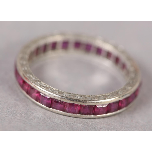 379 - A RUBY COCKTAIL RING in 18ct white gold, c1950, the calibre cut stones channel set with barley corn ... 