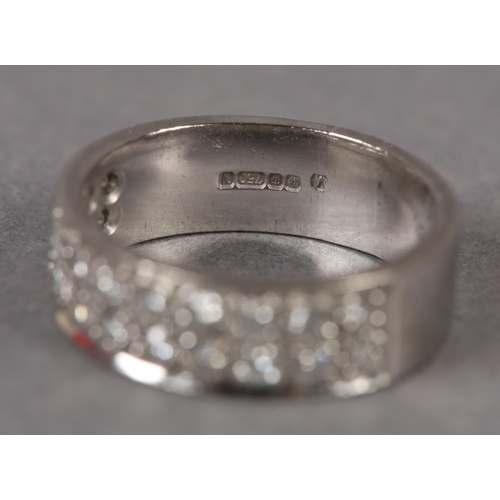 349 - A DIAMOND SET RING IN 18CT WHITE GOLD, the brilliant cut stones grain set to half the band in parall... 