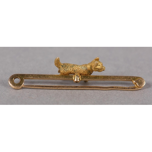 355 - AN EDWARD VII CAIRN TERRIER BAR BROOCH in 15ct gold, the engraved full relief terrier applied to the... 