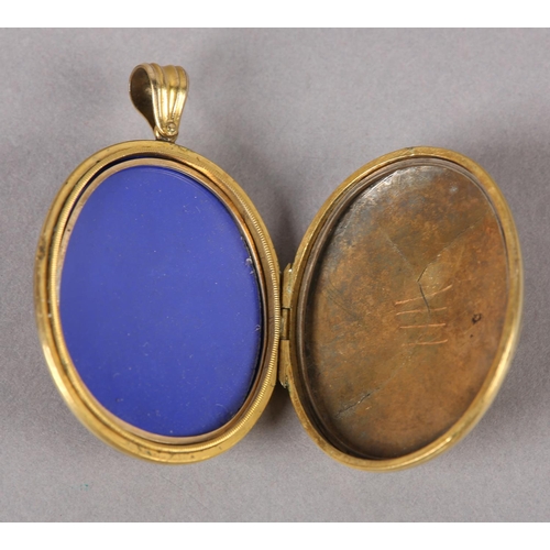 360 - A VICTORIAN OVAL LOCKET in 9ct gold, back and front, foliate engraved with belted surround to the fr... 