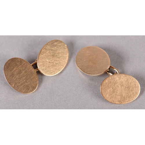 386 - A PAIR OF GEORGE V CUFFLINKS in 9ct rose gold, London 1929, each plain oval face joined by trace lin... 