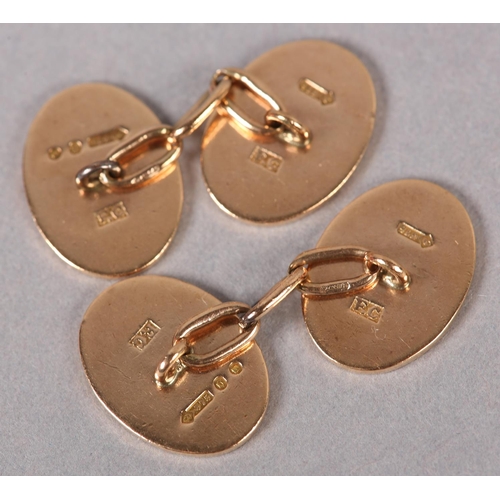 386 - A PAIR OF GEORGE V CUFFLINKS in 9ct rose gold, London 1929, each plain oval face joined by trace lin... 