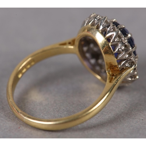 348 - A SAPPHIRE AND DIAMOND CLUSTER RING c1974 in 18ct gold and white gold, claw set to the centre with a... 