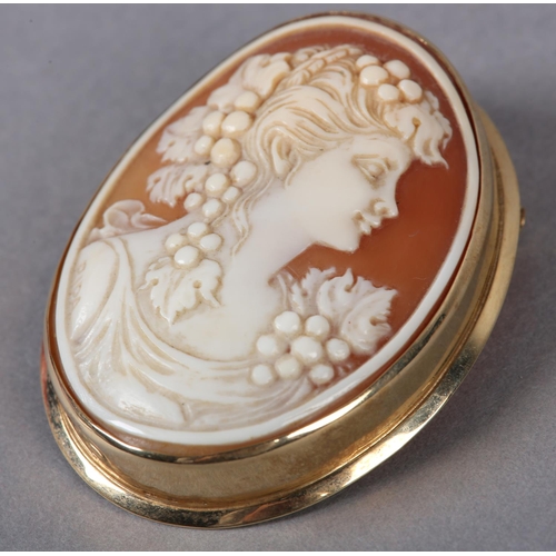 374 - A SHELL CAMEO BROOCH in 9ct gold, the oval female portrait with vine dressed hair, collet set, with ... 