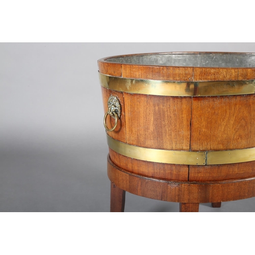 474 - A GEORGE III MAHOGANY AND BRASS BOUND WINE COOLER, of oval outline with lion mask and ring handles, ... 