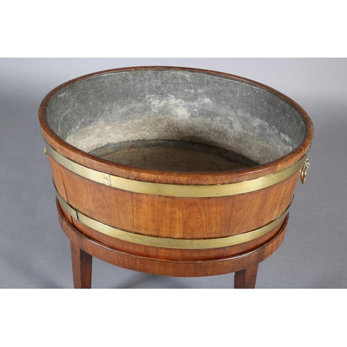 474 - A GEORGE III MAHOGANY AND BRASS BOUND WINE COOLER, of oval outline with lion mask and ring handles, ... 