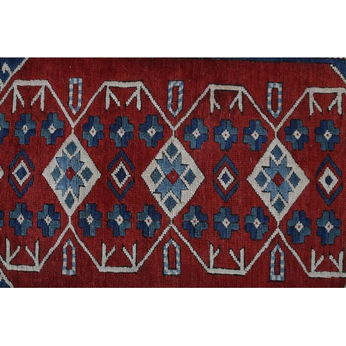 449 - A CAUCASIAN KAZAK RUG, the blue field having a red panel filled with five diamond shape motifs and r... 