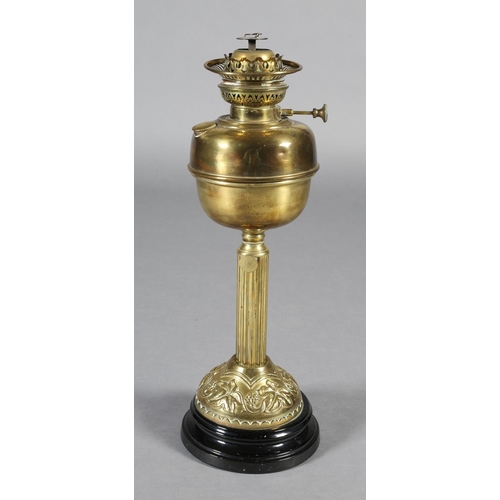 172 - A VICTORIAN BRASS OIL LAMP, on a reeded column, the domed base embossed with grapevine on a black gl... 