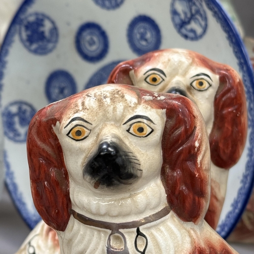 42 - A collection of 19th century and later Staffordshire spaniels including a black and white spotted ex... 