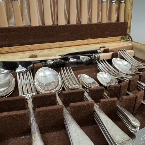 138 - An oak canteen of stainless steel cutlery with ivorine handles