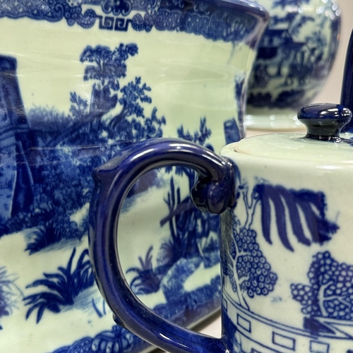 183 - A blue and white ceramic twin handled foot bath, a large jug, a teapot formed as a watering can and ... 