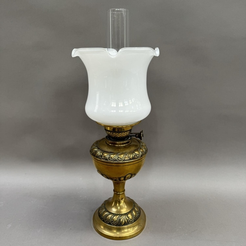 167 - A brass oil lamp having a opaque shade with frilled rim, a clear glass chimney, the brass support mo... 