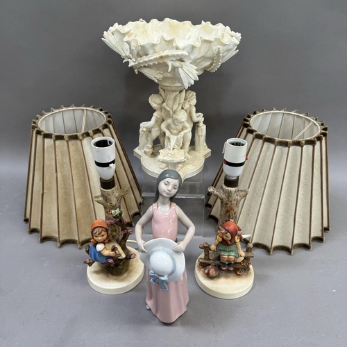 109 - A pair of West German Hummel lamps formed as children, a Lladro figure of a woman and a white porcel... 